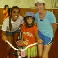 <p>Cristiana Villani, left, fits a bicycle for Ashley Doonan, center, of Rye. </p>