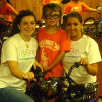 <p>Scott Sullivan, center, 7, gets help adjusting to his new bicycle from Linking Handlebars co-founders Bridget Salice, left, and Lucia Villani, right. </p>