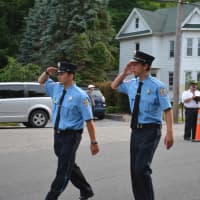 <p>Danbury firefighters give salutes while they march in the Brewster parade.</p>