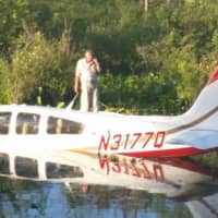 <p>The pilot is waiting on top of his plane awaiting rescue after he landed in a pond near the Danbury Airport. </p>