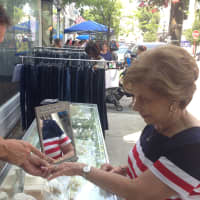 <p>Carol Corwin, of Rye, looks at jewelry at Woodrow Jewelers during the Rye Sidewalk Sales Friday. </p>