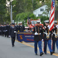<p>A color guard precedes Bedford firefighters marching in their parade.</p>