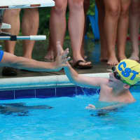 <p>Chappaqua Swim &amp; Tennis Club swimmer Sam Mason is greeted after finishing a race in the !0-Under boys division.</p>