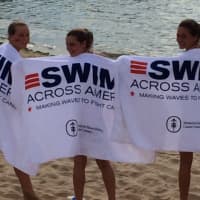 <p>Young swimmers dry off after swimming to raise funding for cancer research and awareness at the Swim Across America-Long Island Sound Swim on July 26.</p>