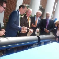 <p>Gov. Dannel P. Malloy, second from left, jokes with Wilton First Selectman Bill Brennan, center, after they and other officials signed an 8-inch polyethylene pipe during a press conference Monday announcing the expansion of Yankee Gas into the town.</p>
