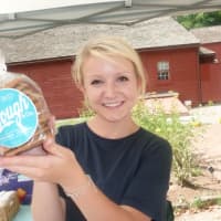 <p>Christine Blaisdell, an employee of the South Norwalk-based Dough &amp; Co., holds up one of its bag of cookies at the Wilton Farmers Market.</p>