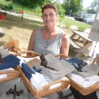 <p>Anita Sobelson, of Weston, owner of Anita Designs, shows off some of her linen products at the Wilton Farmers Market.</p>