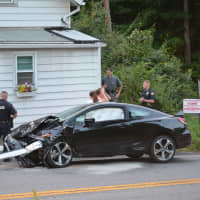 <p>A damaged black car by the intersection of Stoneleigh Avenue and Drewville Road in Carmel.</p>