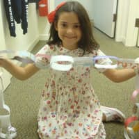 <p>Violet Diaz, 8, displays a paper chain she made at the Westport Historical Society.</p>