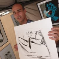 <p>Paul Fernandez-Carol displays one of his ink on paper creations of surfboards in a station wagon. He owns the Seven Arts Gallery of Ridgefield.</p>