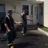 <p>Firefighters Tyler Prescott and Jeff Pinckney monitoring the broken gas line at the Garden Court home.</p>