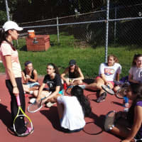 <p>First-year girls tennis coach Caroline Gizzi talks to her players during a Tuesday, Aug. 19 practice.</p>