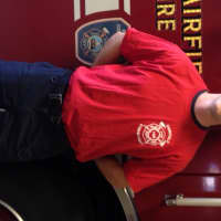 <p>Firefighter Jordan Charney in a red uniform t-shirt.</p>