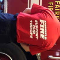 <p>Firefighter Jordan Charney in a Fairfield Fire &quot;Support Our Troops&quot; red uniform t-shirt.</p>