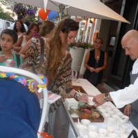 <p>Brian Lewis, owner of Elm Restaurant, passes out some samples during the Taste of the Town Stroll Thursday.</p>
