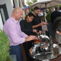 <p>Benny Dedushi, at left, general manager at Solé hands samples during the Taste of the Town Stroll Thursday in New Canaan. </p>