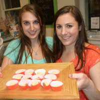 <p>Megan Paladino, left and Lauren Palladino, owners of The Candy Scoop hold up samples of Kentucky Butterrum Cake during Thursday&#x27;s Taste of the Town Stroll in New Canaan. </p>