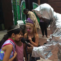 <p>The tin man helps Bianca Flores (left), Janelle Robertson (center) and Lacey Carr (second from right) get set up. </p>