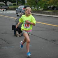 <p>A girl cruises toward the finish line in Friday&#x27;s All Out For Autism race in New Canaan. </p>