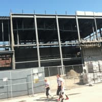 <p>Greenwich High School football players walk by construction of the Music Instructional Space &amp; Auditorium at the high school on the first day of classes Tuesday.</p>