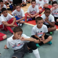 <p>Young basketball players listen to New York Knicks player Iman Shumpert at his clinic in Ardsley.</p>
