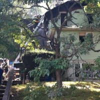 <p>Norwalk firefighters put out the last smoldering remains of the house fire on Riverside Avenue on Thursday.</p>
