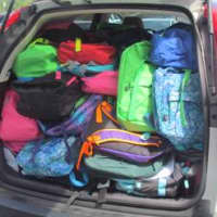 <p>A van is packed with all the backpacks. </p>