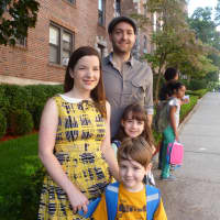 <p>Andrew (back right) and Karen Binder (left) wait for the school bus with their children Shane, 5, and Cassia, 8. </p>