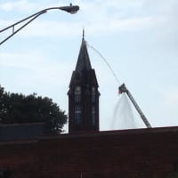 <p>Firefighters attack the blaze on the steeple at Little Zion Church of Christ, 4 Martin Luther King Jr. Drive, South Norwalk. </p>