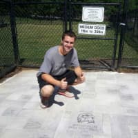 <p>Brandon Pelter at the newly completed entrance to the dog park.</p>