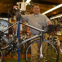<p>Mike Conlin stands behind a cutting-edge bike at Outdoor Sports Center.</p>