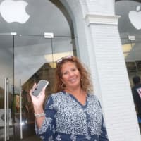 <p>Greenwich resident Sandra Valentin holds up her iPhone 5S. She said she would like to get one of the new iPhones that were unveiled Tuesday. They are not in Apple stores yet.</p>