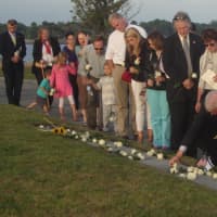 <p>Families and friends of those who died on Sept. 11 line up to place flowers on the memorial in Westport.</p>
