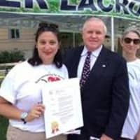 <p>Pam Liflander and Elyse Brown receive the Proclamation from David Theis</p>