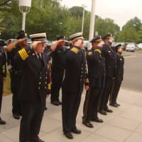 <p>Members of the Norwalk Fire Department and Norwalk Police Department stand in salute during the 9/11 ceremony.</p>