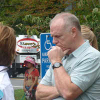 <p>An attendee at the New Canaan 9/11 ceremony pauses to remember. About 80 people gathered in front of police headquarters for the event that began at 9:59 a.m., the same time the first tower collapsed at the World Trade Center on Sept. 11, 2001.</p>