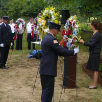 <p>Firefighters place one of three wreaths in front of the Girl Scout Rock Memorial. </p>