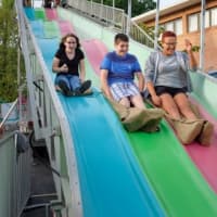 <p>Family and friends went down the big slide, one of the many carnival rides at the Greek Festival.</p>