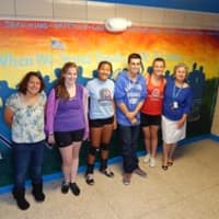 <p>Jan Aiello and student artists with their Invincible mural.</p>
