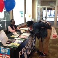 <p>Brenda Hudson (left) registers someone to vote in the White Plains City Center Tuesday. </p>