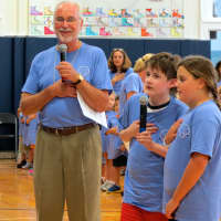 <p>Assistant Principal Terry Costin and fifth-grade students lead the school in the Pledge of Allegiance.</p>