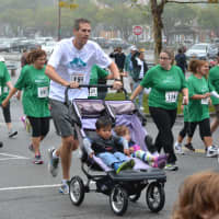 <p>A father runs with his children in a stroller. </p>