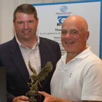 <p>From left: R. Todd Rockefeller, Boys &amp; Girls Club of Northern Westchester board president, golf tournament committee member and event emcee, presents an award to John Ventosa, representing Gold Sponsor and long-time supporter Entergy.</p>