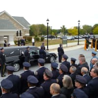 <p>Visiting police stand towards the hearse containing Michael Williams&#x27; casket outside of a LaGrangeville church.</p>