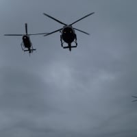 <p>Three helicopters fly overhead as folks gather for an outdoor ceremony following indoor funeral services for Michael Williams.</p>
