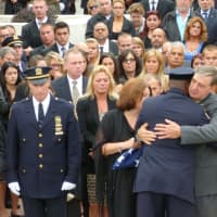 <p>A hug is given during the outdoor ceremony for Michael Williams.</p>