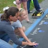 <p>Sixth-grade Girl Scout Hailey Videla places her hand print on the mural at Pequenakonck Elementary School.</p>