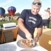 <p>Victor Malindretos of the mobile wood-fired brick oven Easton-based catering company Skinny Pines slices pizza at Go Wild!</p>