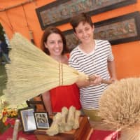 <p>Anne Hopkinson, left, and Janelle Higdon, of Haydenville Broomworks, display an old-fashioned broom that they make and sell. They are located in Haydenville, Mass., and were at the Ambler Farm fall festival on Sunday.</p>
