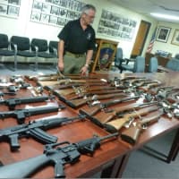 <p>Stamford Police Sgt. Tom Wolff looks over the handguns, rifles and automatic rifles turned in to police as part of the gun buyback program.</p>